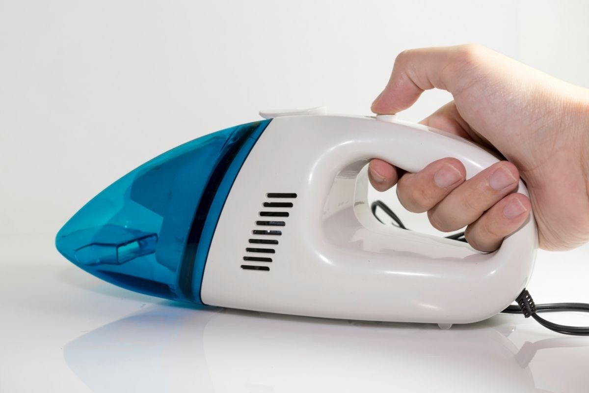 Hand holding mini vacuum cleaner